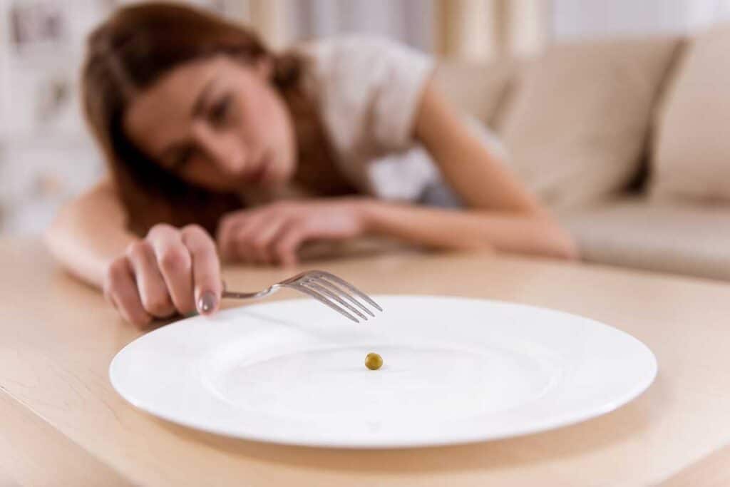 Junge Frau erschöpft wegen Mangelernährung